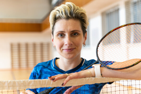 Female badminton player takes a break at the net