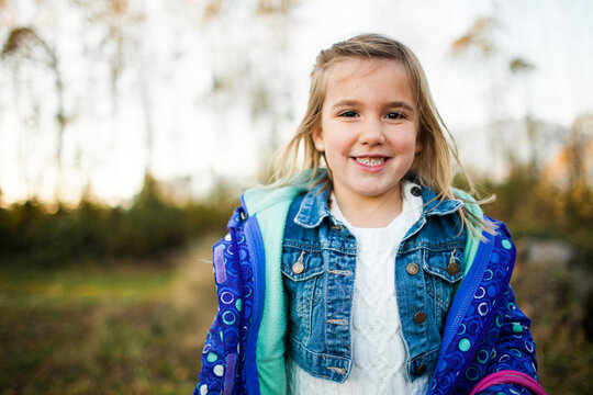 Happy little girl with braces smiling outside