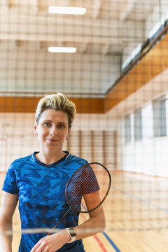 Confident female athlete holding a badminton racket