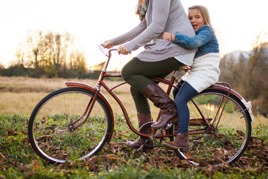 Woman giving daughter ride on vintage bicycle