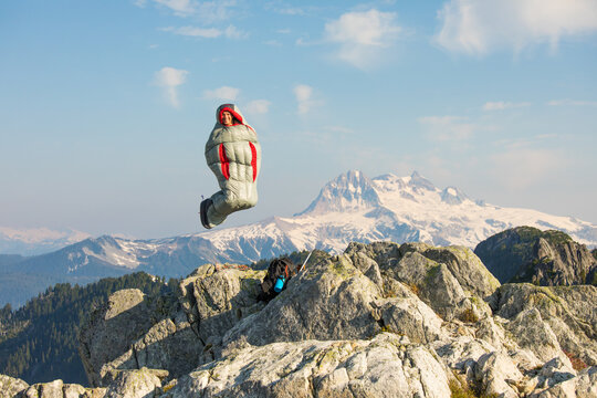 Happy man jumping mid air in a sleeping bag