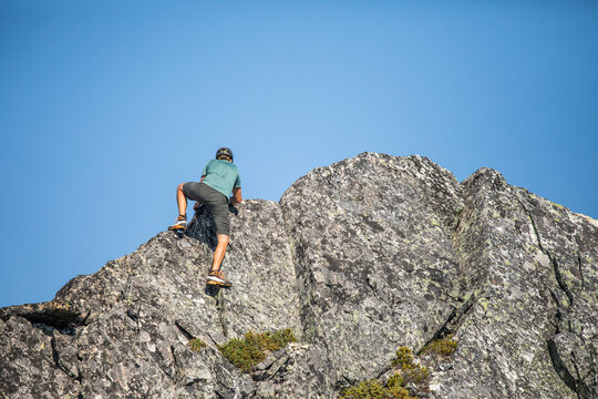 Man rock climbing up a mountain peak