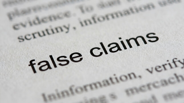 Close-up of dictionary page with false claims definition, misinformation concept