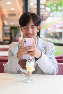 Portrait of smiling non-binary Thai Isan person taking food photo