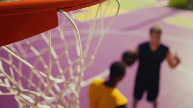 Two male basketball players on a vibrant outdoor court, one soaring for a dunk while the defender leaps to block, energetic streetball action and athletic competition