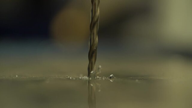 Close-up drilling hole in metal sheet on automated machine equipment on factory.