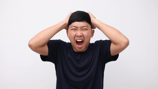 Man sreaming and feeling very angry at face show fists up,Asian man shout very loudly white background slow motion