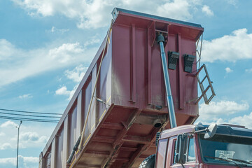 Heavy duty dumper truck with raised red tipper body unloading ca © kalyanby