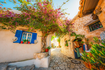 Obraz premium Alley decorated with flowers in the picturesque village of Afionas vacation on the island of Corfu in Greece near Porto Timoni beach
