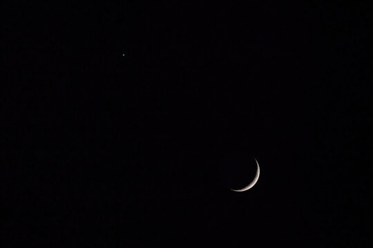 The waxing moon and Venus in the dark night sky