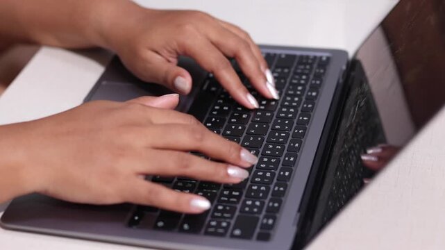 Close up woman hand typing keyboard laptop on table slow motion
