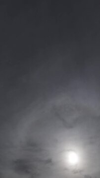 Fast moving overcast clouds time lapse with sun glow in vertical 4K