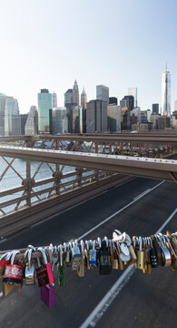Love padlocks secured on the Brooklyn Bridge railing overlooking the East River and Lower Manhattan skyline, highlighting romantic travel and urban tourism in New York City, USA.