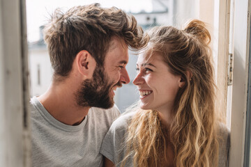 Naklejka premium couple stands joyfully by open door smiling brightly at each other radiating warmth