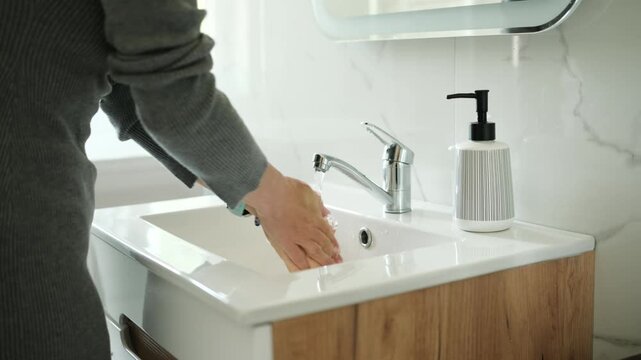 Close-Up View From Above Of A Woman Washing Hands With Liquid Soap In The Bathroom