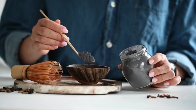 Woman Measures Tea For Making Blue Matcha Tea Into A Bowl