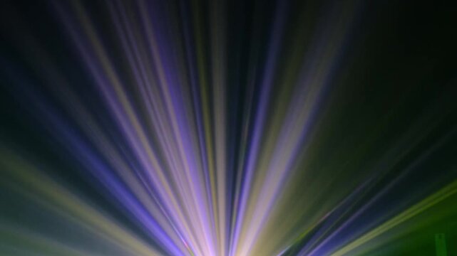 Lasershow with Multiple Laser Beams in Fog, The concepts of performance arts, Colored light beams from reflector through the foggy night sky