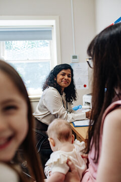 Healthcare professional meets a family with two young children inside consultation room