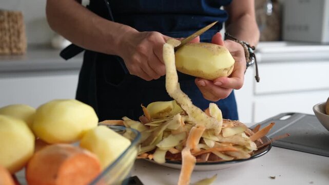 Woman Peeling Potatoes In Close-Up