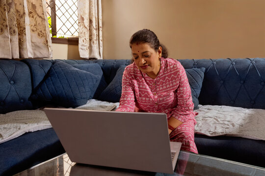 Mother working on a laptop in a quiet living room