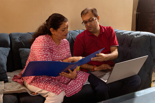Couple reviewing documents on sofa