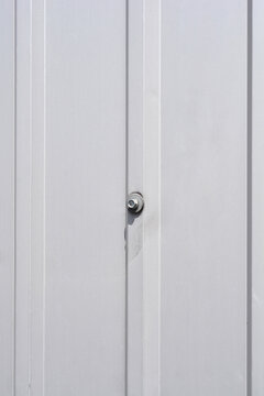 A close up front view of a grey corrugated metal siding sheet with a single self tapping hex head screw fixing the profile panel