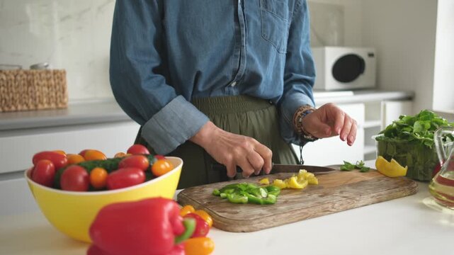 Woman Slicing Yellow And Green Pepper For Salad