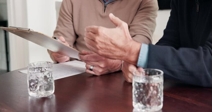 Hands, old man or agent with document in meeting for medicare options, long term care or explain. Talk, senior client or insurance broker with clipboard in home for beneficiary review, policy or help
