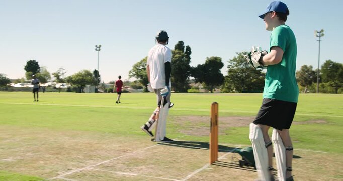 When bowler coming from right, green-shirted wicketkeeper crouching at stumps grabbing ball