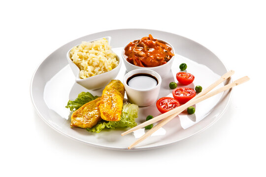 Fried chicken nuggets, white rice and vegetables on white background

