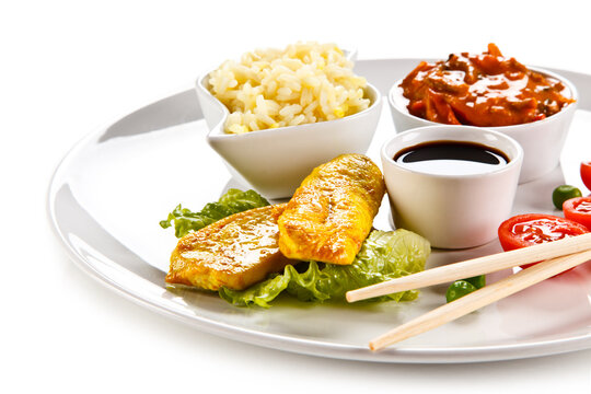 Fried chicken nuggets, white rice and vegetables on white background
