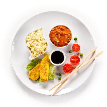 Fried chicken nuggets, white rice and vegetables on white background
