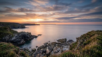 Obraz premium Stunning Coastal Sunset with Rocky Shoreline and Calm Waters