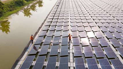 Professional workers clean and inspect solar panels on a floating buoy. Power plant with water  © eakarat