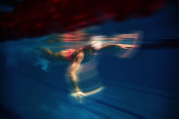 Swimmer gliding underwater with artistic motion blur effect. Concept of anonymous sport poster, speed and motion blur, athletic competition, sports energy background. © master1305