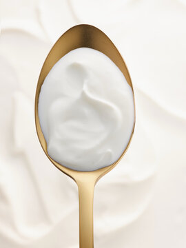 Yogurt served on a golden spoon, perfect for healthy lifestyle promotions and gourmet menus