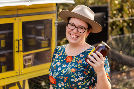 woman holding jar of honey purchased at roadside stall from small local business