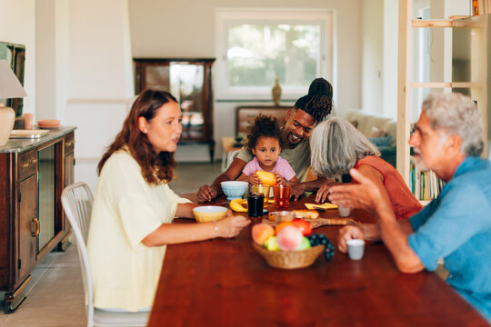 Multigenerational family enjoying breakfast conversation at home