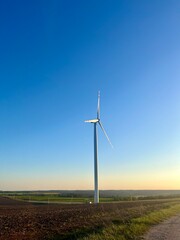Fototapeta premium wind turbine in the green field in sunset view