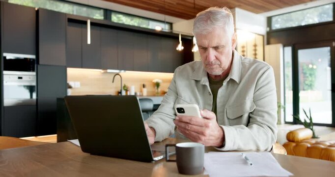 Typing, phone and laptop with man in kitchen for social media, ebook subscription and relax. Connection, internet and mature person in home, technology for communication and online reading