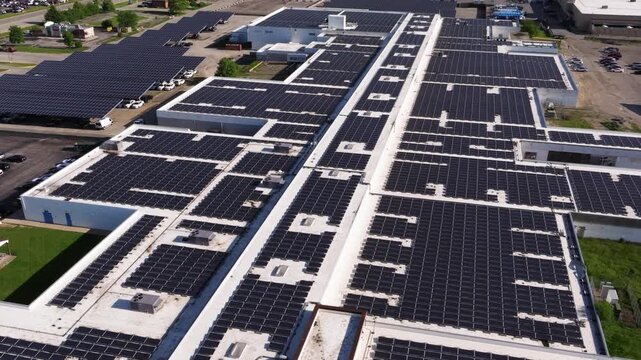 Data center rooftops covered with solar panel arrays and large parking lot panels, drone overview
