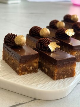 Luxury Chocolate Hazelnut Mignon Cakes with Edible Gold Leaf on White Plate
