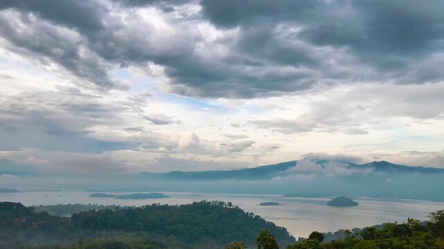 Beautiful morning panoramic view of Jatigede dam reservoir lake with hills covered in thick mist and clouds. Sumedang, Indonesia.