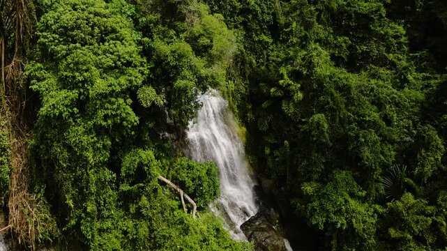 Drone view of multiple waterfalls cascading through dense tropical jungle greenery. Na Mueang Waterfall. Ko Samui, Thailand.