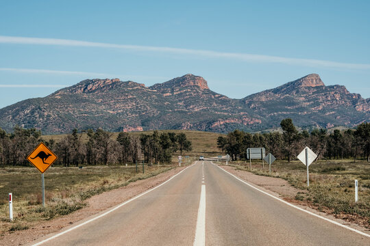 Kangaroo crossing sign on road leading to mountain ranges