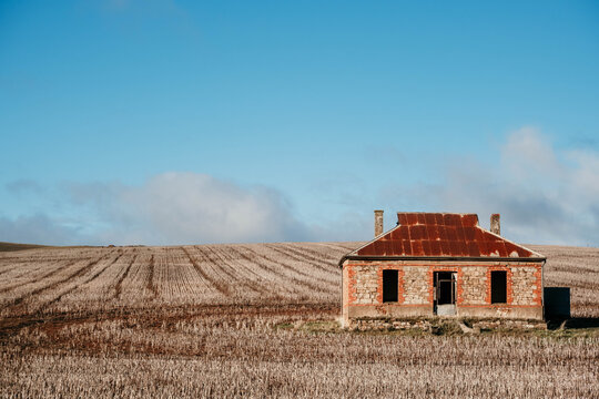 Old abandoned house with just harvested landscape.