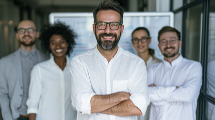Obraz premium Confident diverse business team standing together in a modern office, smiling and looking at the camera, representing teamwork and professional success.