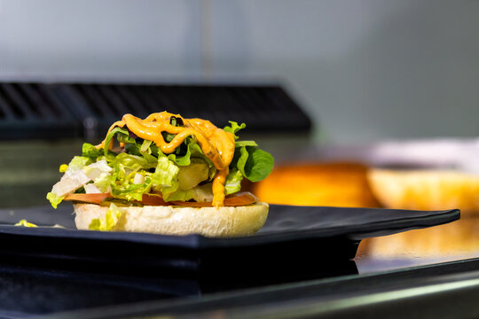 Gourmet burger bun with fresh lettuce, tomato and a creamy sauce