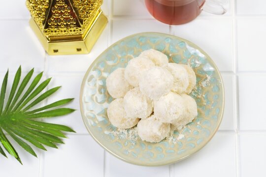 Kue Putri Salju or Snow White Cookies ,Traditional powdered sugar cookies served with tea and decorative setup.