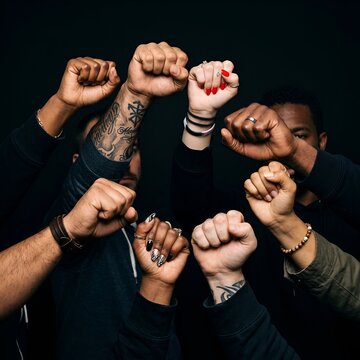 Diverse group raising fists in unity and protest, black background